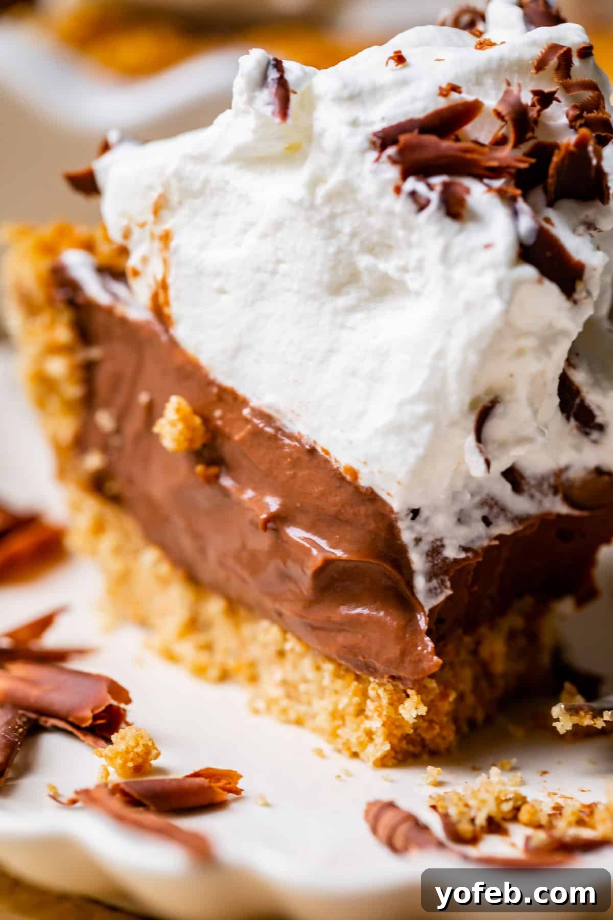 Decadent Chocolate Cream Pie Perfection 32 A whole chocolate cream pie with a graham cracker crust, generously topped with whipped cream and chocolate shavings.