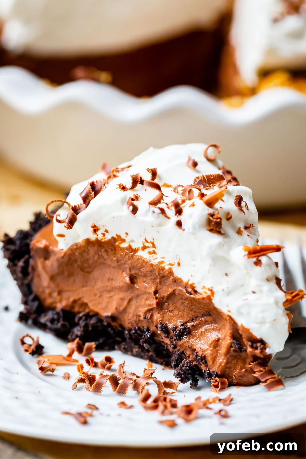 Decadent Chocolate Cream Pie Perfection 34 easy chocolate cream pie recipe with oreo crust on a white plate.