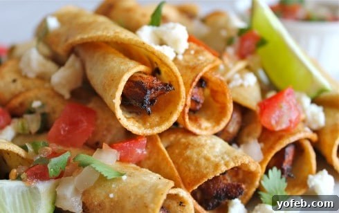 Crispy Chicken Flautas. A family favorite, quick enough for weeknights or perfect for parties. #fried #chicken #flauta #Mexican #easy #authentic #picodegallo #dinner #tortillas A close-up shot of golden, crispy chicken flautas, beautifully arranged.