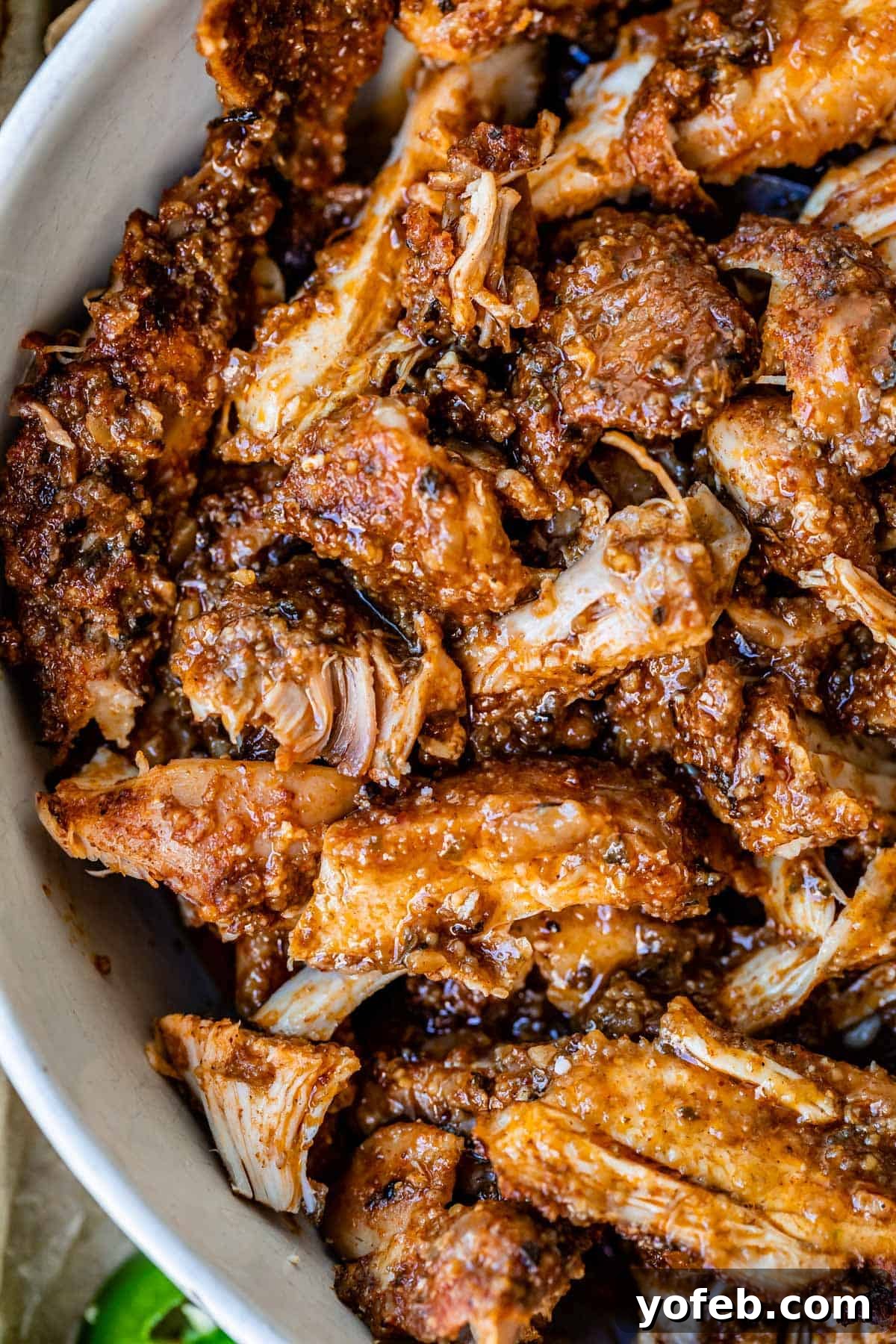 Ultimate Chicken Tacos Quick and Slow Cooker Options 15 super close up picture of cooked, shredded chicken with tons of seasoning in a white bowl.
