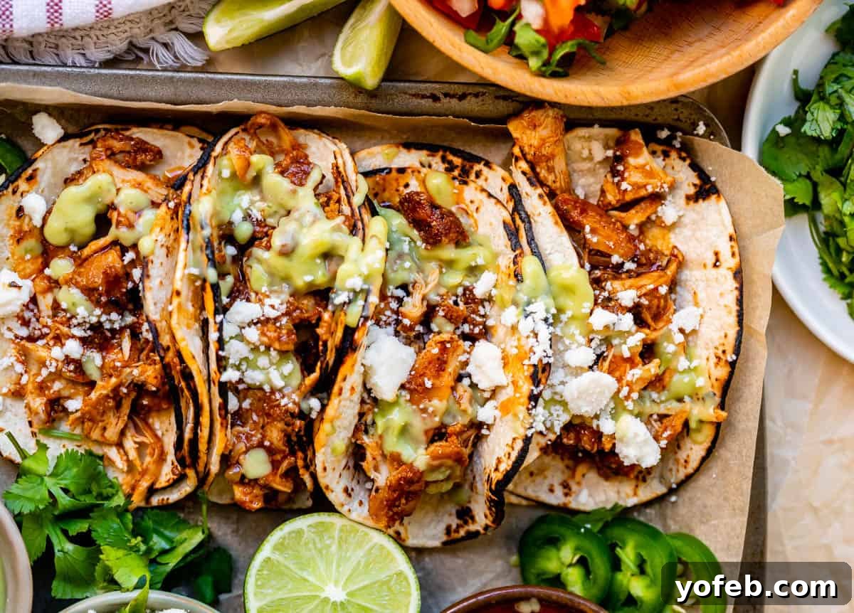 Ultimate Chicken Tacos Quick and Slow Cooker Options 20 four crock pot chicken tacos side by side in charred corn tortillas with juicy meat, cotija, and green salsa.