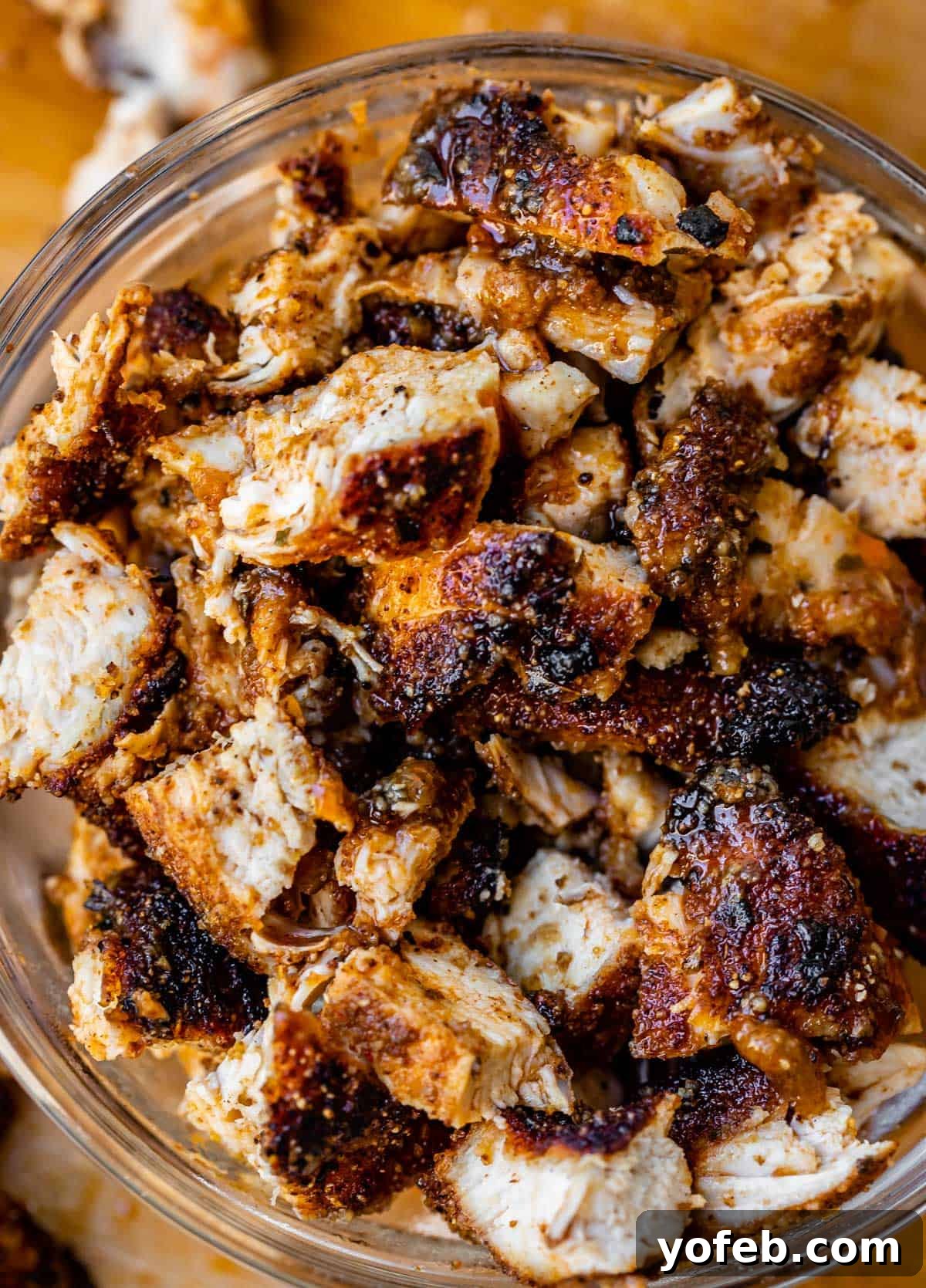 Ultimate Chicken Tacos Quick and Slow Cooker Options 5 a glass bowl filled to the top with chopped, cooked chicken that is seasoned well.