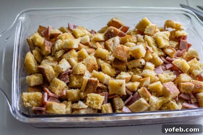 Brunch-Ready Overnight Eggs Benedict Bake 10 Chopped English muffins and Canadian bacon are layered in a casserole dish, creating the base for the Eggs Benedict bake.