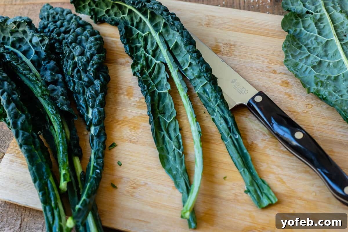 Mastering the Art of Italian Wedding Soup 21 kale leaves on cutting board showing how to cut out the spine.