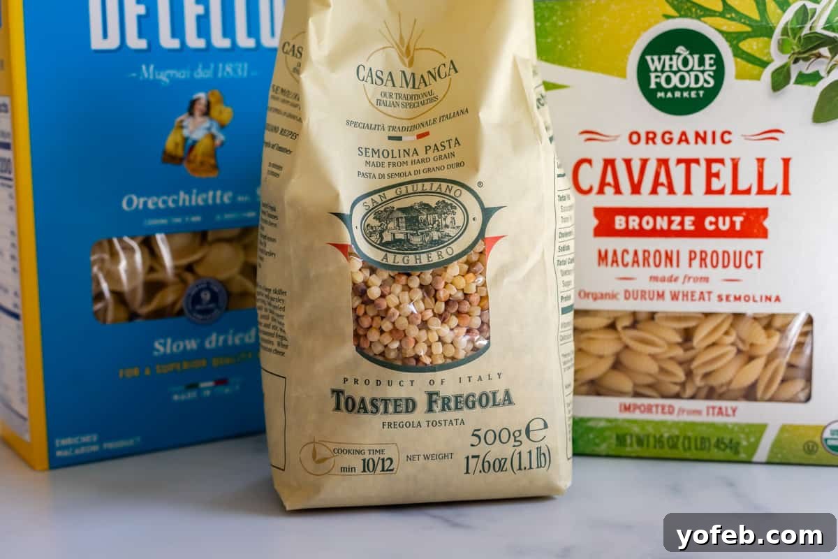 Mastering the Art of Italian Wedding Soup 7 three different types of pasta; fregola, cavatelli, and orecchiette in packaging on a counter.