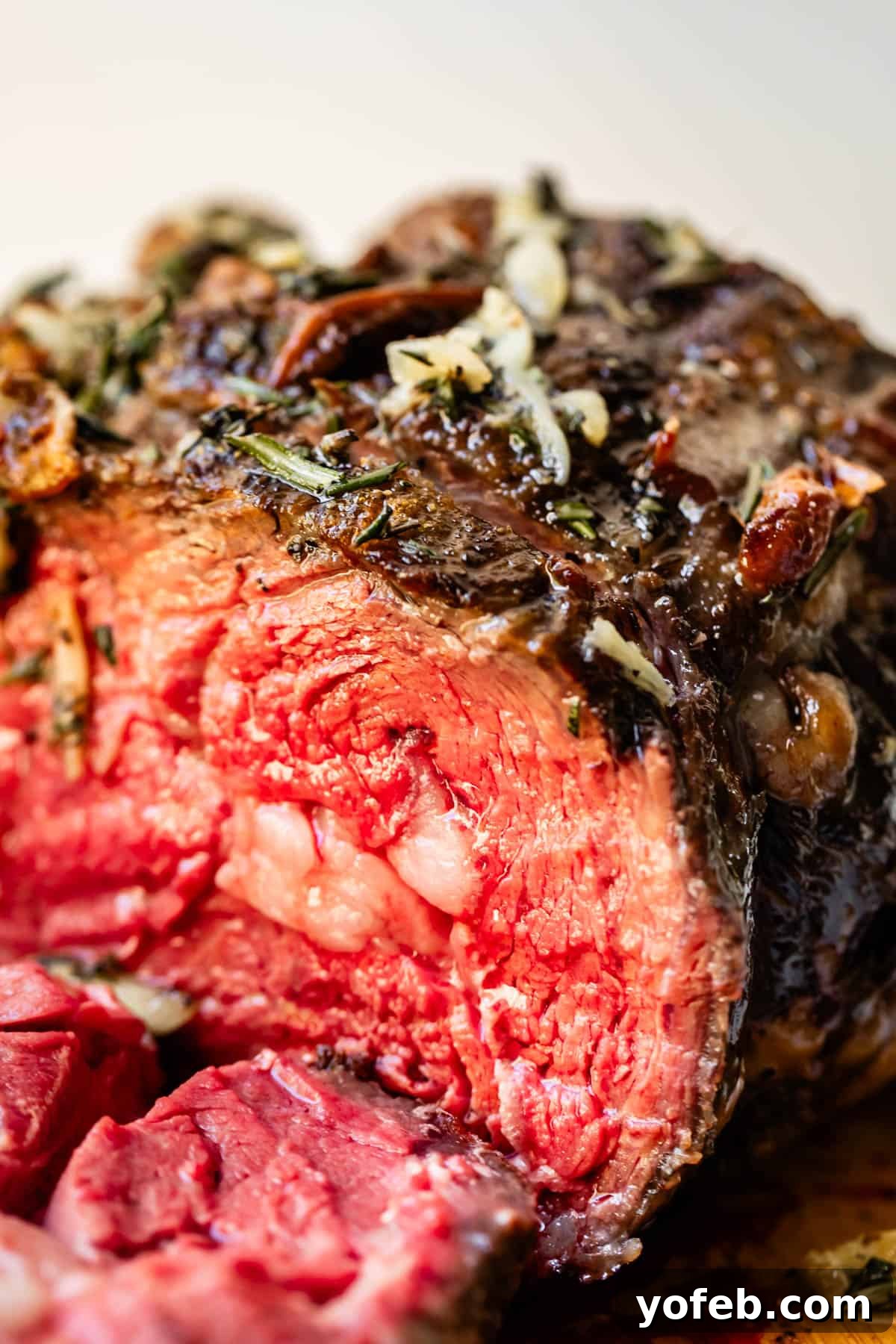 Wow Your Guests With This Perfect Prime Rib 11 A stunning cross-section of perfectly cooked prime rib, displaying a vibrant red interior indicative of a delicious rare doneness. The edges are beautifully seared and golden brown.