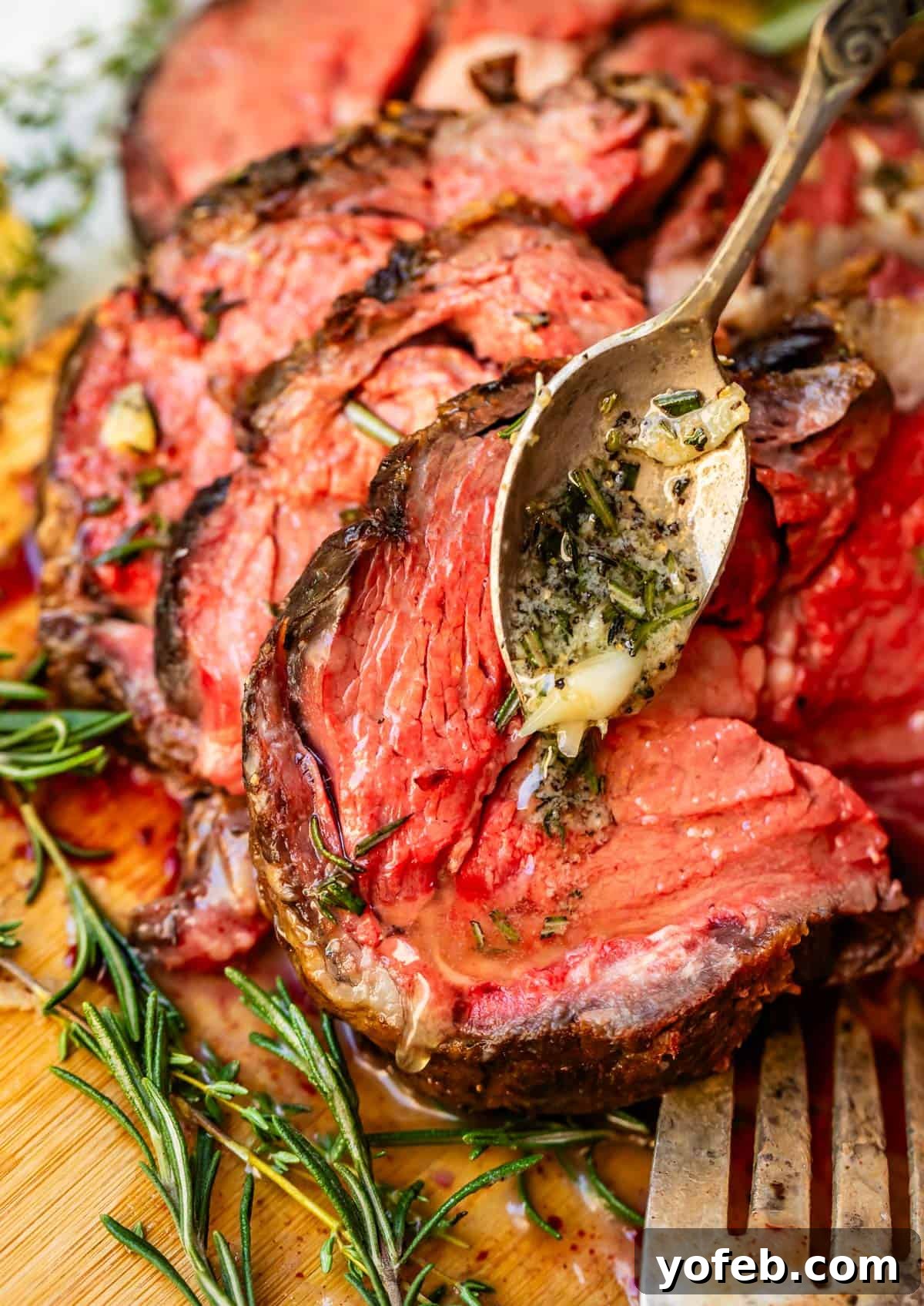 Wow Your Guests With This Perfect Prime Rib 3 Succulent slices of prime rib, artfully arranged and leaning against each other on a bamboo cutting board, garnished with fresh sprigs of thyme.