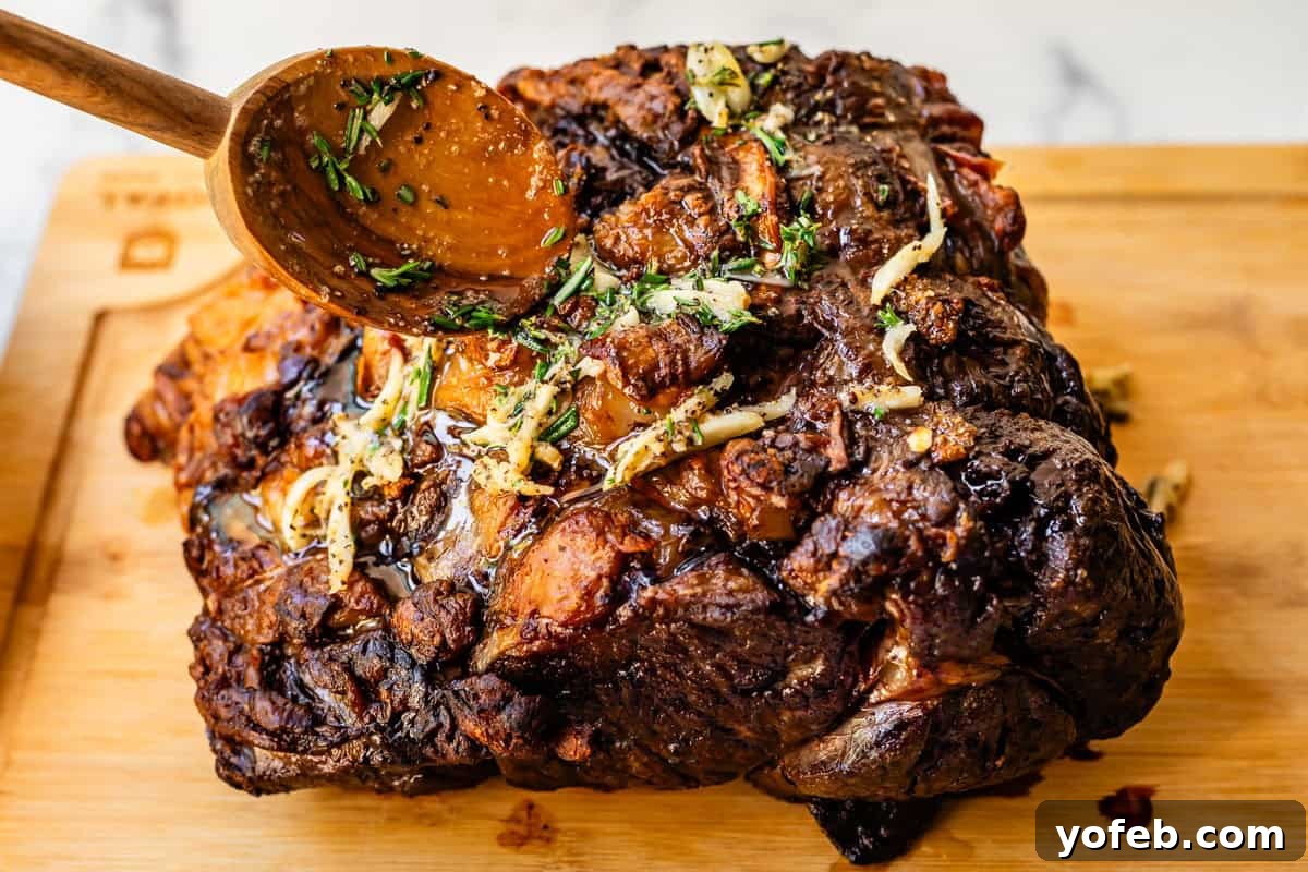 Wow Your Guests With This Perfect Prime Rib 30 A wooden spoon delicately pours glistening garlic butter sauce over the golden, crusty top of the prime rib roast, enhancing its aroma and flavor.