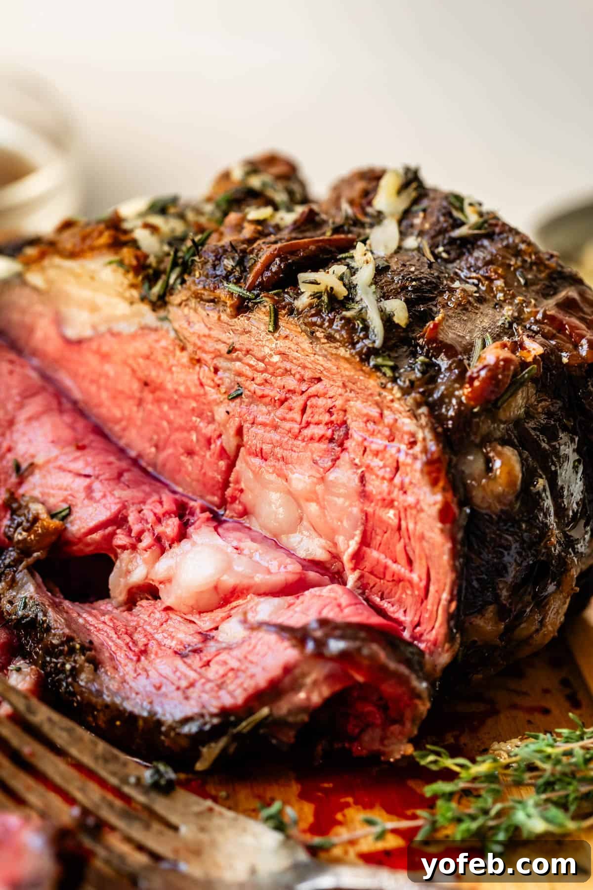 Wow Your Guests With This Perfect Prime Rib 31 A magnificent prime rib roast, boasting a perfectly cooked, rare interior and a beautifully crusted outer layer, stands proudly with a single slice already carved, inviting diners to savor its tenderness.
