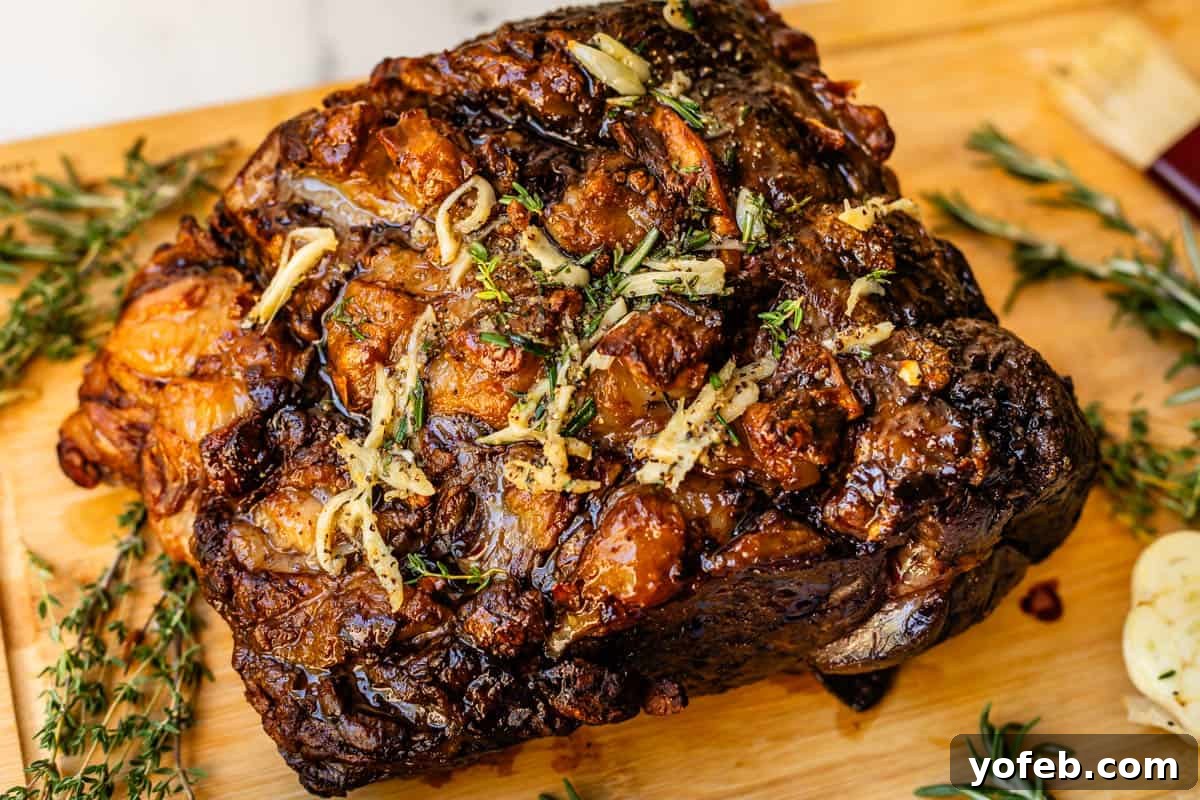 Wow Your Guests With This Perfect Prime Rib 32 A perfectly cooked prime rib roast, golden brown and glistening, rests on a cutting board, generously drizzled with aromatic garlic butter. It's ready for carving and serving.