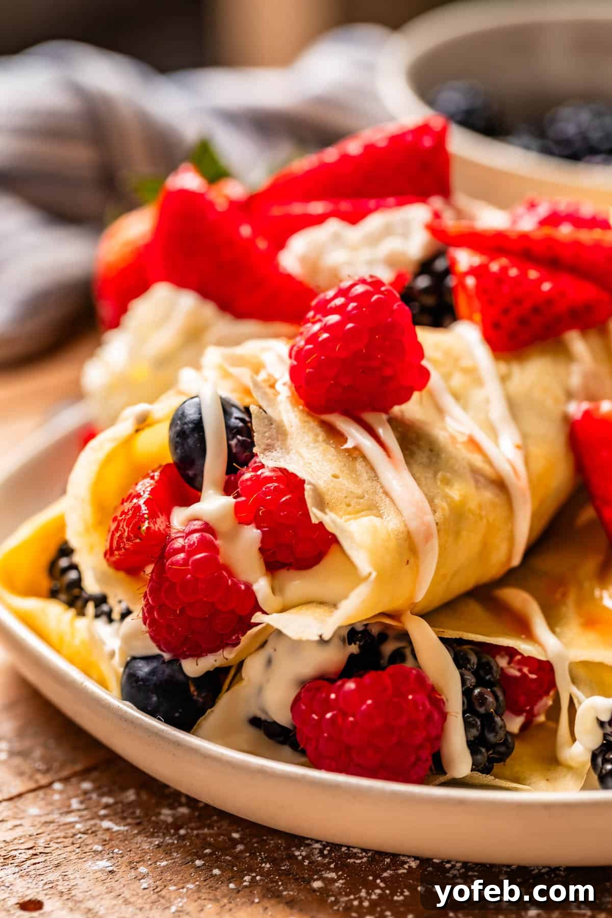 Absolutely The Best Crepes 5 Soft, delicate crepes filled burrito-style with a luscious cream cheese spread and an assortment of fresh mixed berries, showcasing a perfect balance of sweet and tangy flavors.