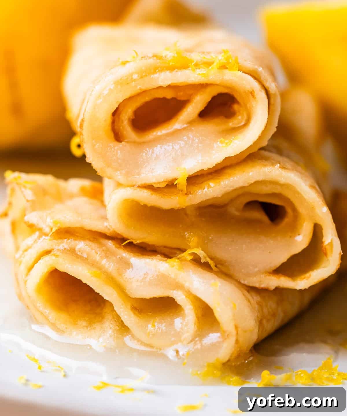 Absolutely The Best Crepes 8 Three perfectly rolled crepes, each filled with a delightful combination of fresh lemon juice and granulated sugar, offering a vibrant and zesty sweet treat.