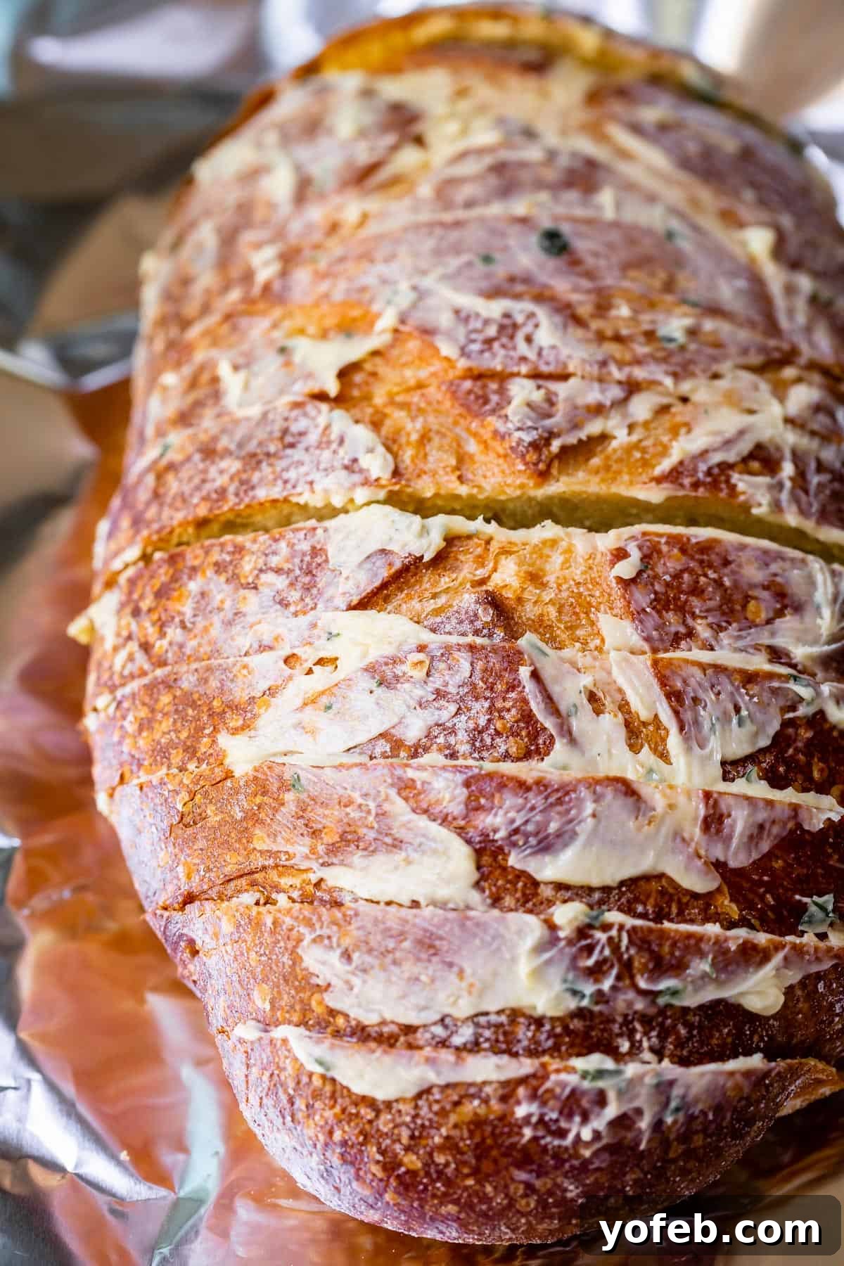 Irresistible Garlic Butter Loaf 22 Sliced crusty bread reassembled into a loaf shape, with homemade garlic butter spread generously on the top crust.