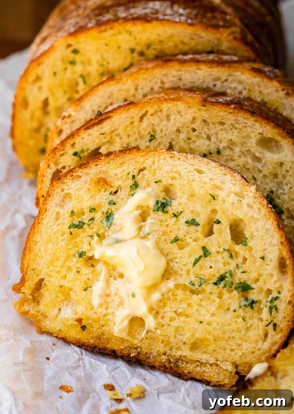 Irresistible Garlic Butter Loaf 25 Several slices of baked garlic bread, glistening with melted butter, minced garlic, and fresh parsley.