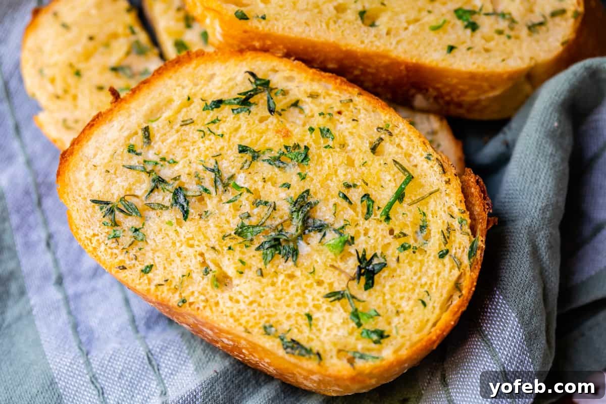 Irresistible Garlic Butter Loaf 26 Close-up of a single slice of baked garlic bread, showcasing its melted butter, crispy edges, and soft center.