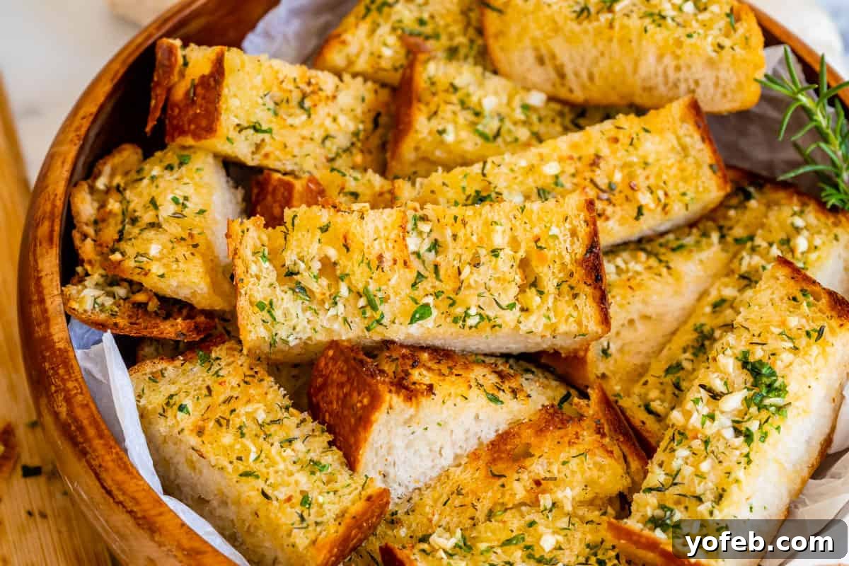 Irresistible Garlic Butter Loaf 6 Horizontal shot of easy garlic bread with crispy edges and fresh parsley, presented in a wooden bowl.