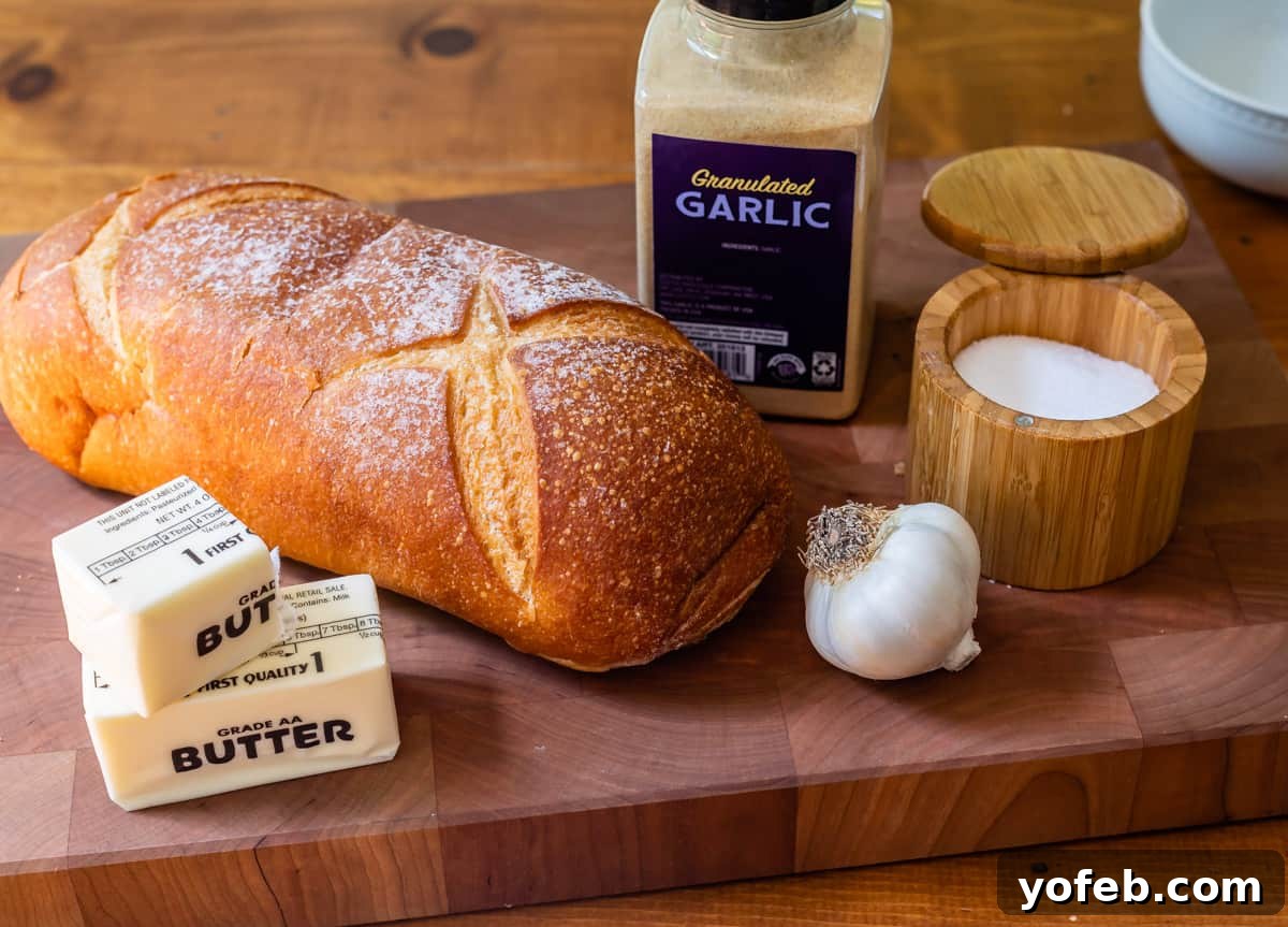 Irresistible Garlic Butter Loaf 7 Ingredients laid out for garlic bread: fresh bread, butter, salt, fresh garlic, and granulated garlic powder.