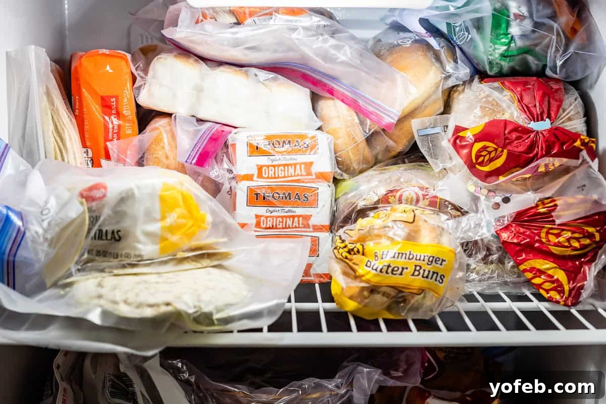 The Ultimate Guide to a Fully Stocked Pantry and Fridge 9 The top shelf of a freezer, neatly organized with frozen bread, dinner rolls, tortillas, and hamburger buns.
