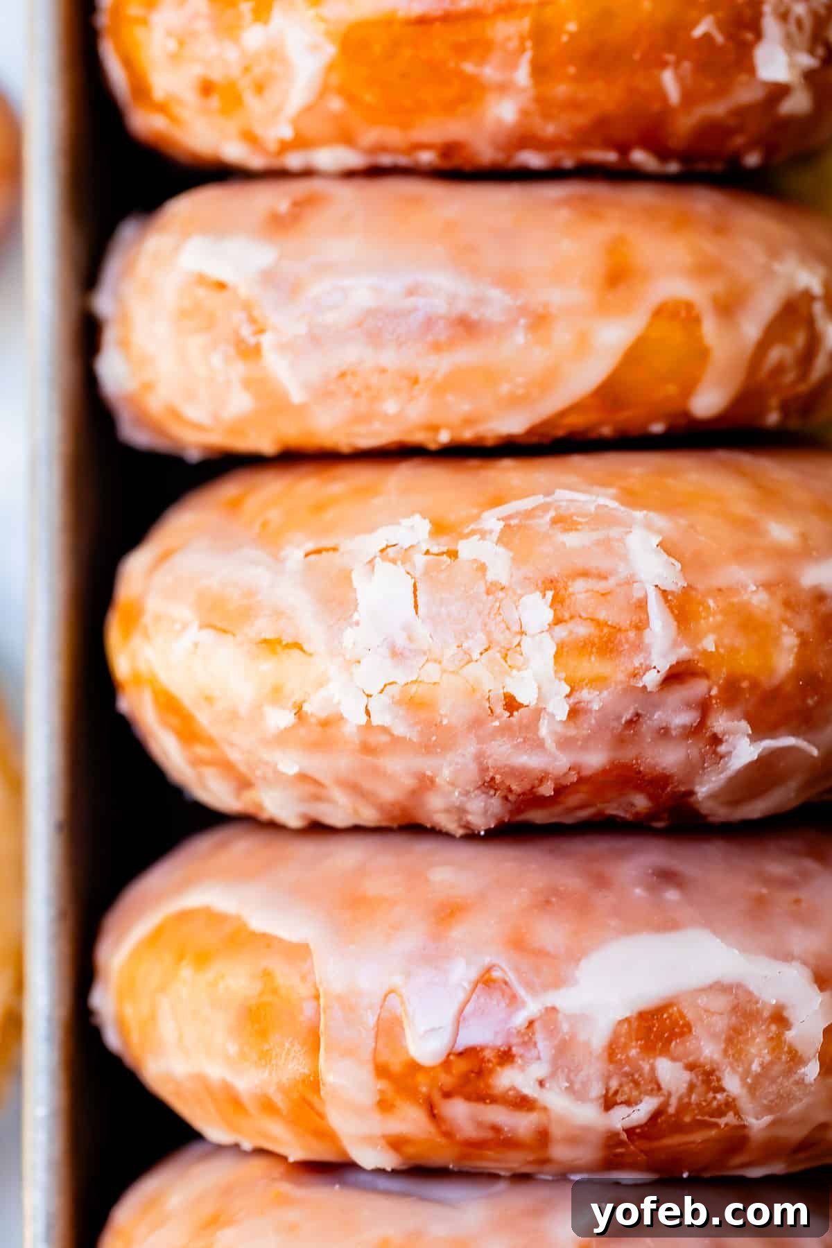 Doughnut Delights from Scratch 5 Side view of a stack of the best homemade glazed donuts, clearly showing the beautiful cracks in the glaze.