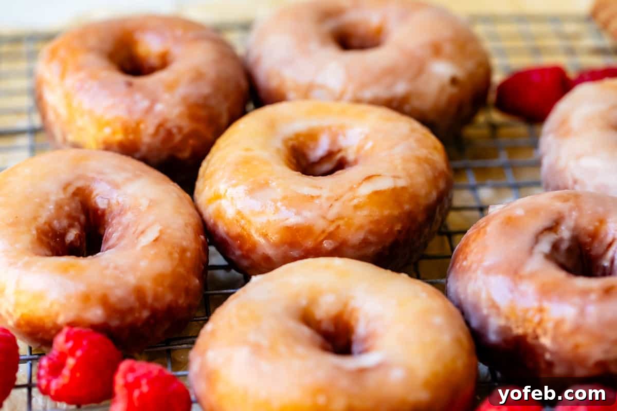 Doughnut Delights from Scratch 7 Several perfectly fried and glazed homemade donuts arranged neatly on a cooling rack, glistening with sweet glaze.