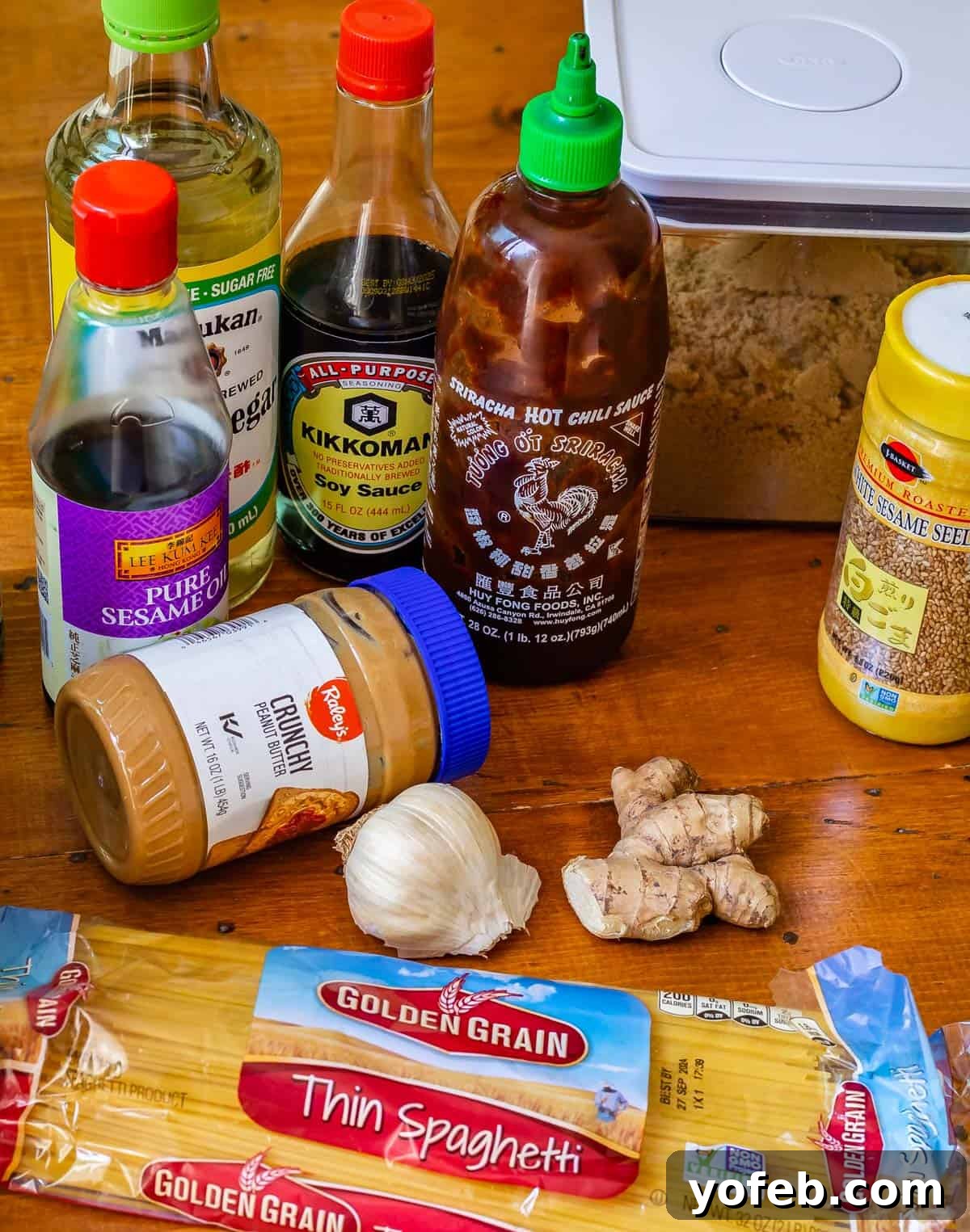 Vibrant Spring Sesame Noodles 6 A vibrant flat lay of all the essential ingredients laid out for making cold sesame noodles, including spaghetti, fresh vegetables, and sauce components.