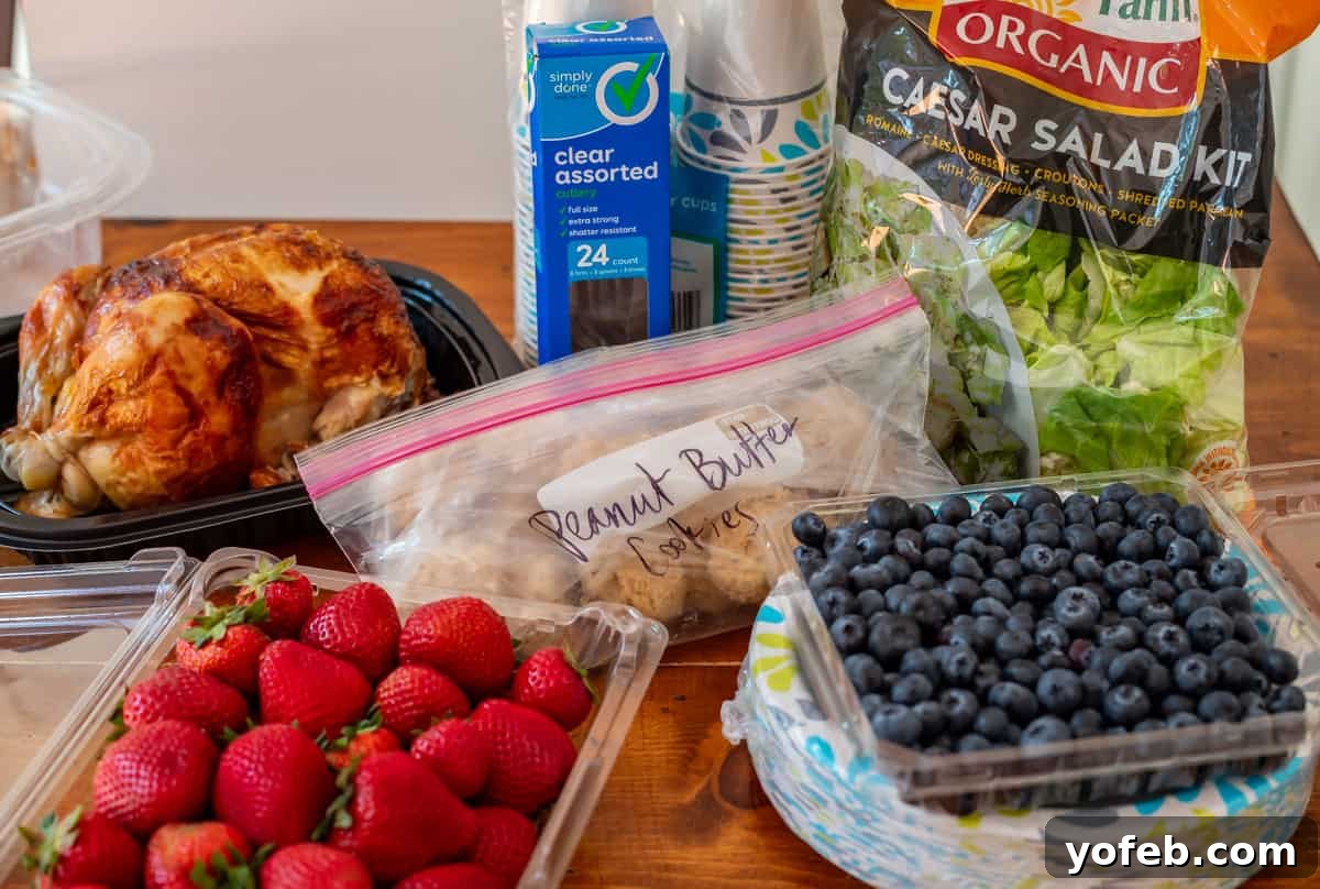 Cooking Up Kindness: Delivering Meals to Loved Ones 3 A thoughtful grocery store spread: rotisserie chicken, strawberries, blueberries, a salad kit, and cookie dough balls arranged on a table.