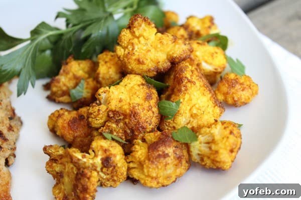 Serving of roasted curry cauliflower sprinkled with fresh parsley