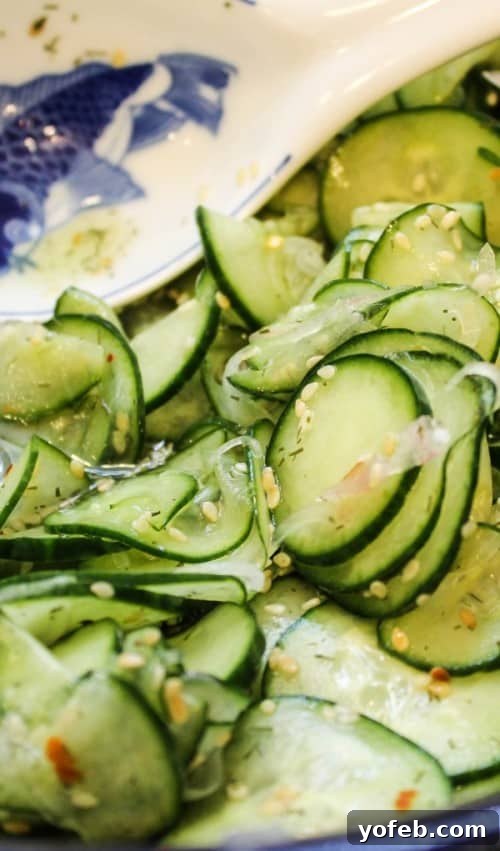 Crisp Asian Cucumber Salad with Tangy Rice Vinaigrette 5 marinated asian cucumber salad with rice vinegar next to a blue and white spoon rest.