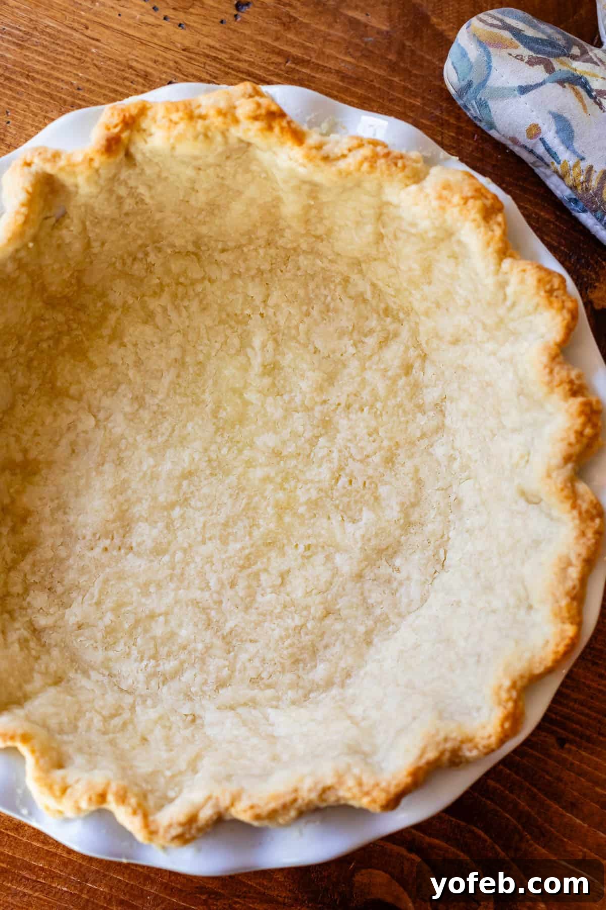 Golden Sweet Potato Pie Crowned with Salted Caramel Cream 17 a perfectly browned par-baked pie crust in a white pie dish ready for sweet potato pie filling.