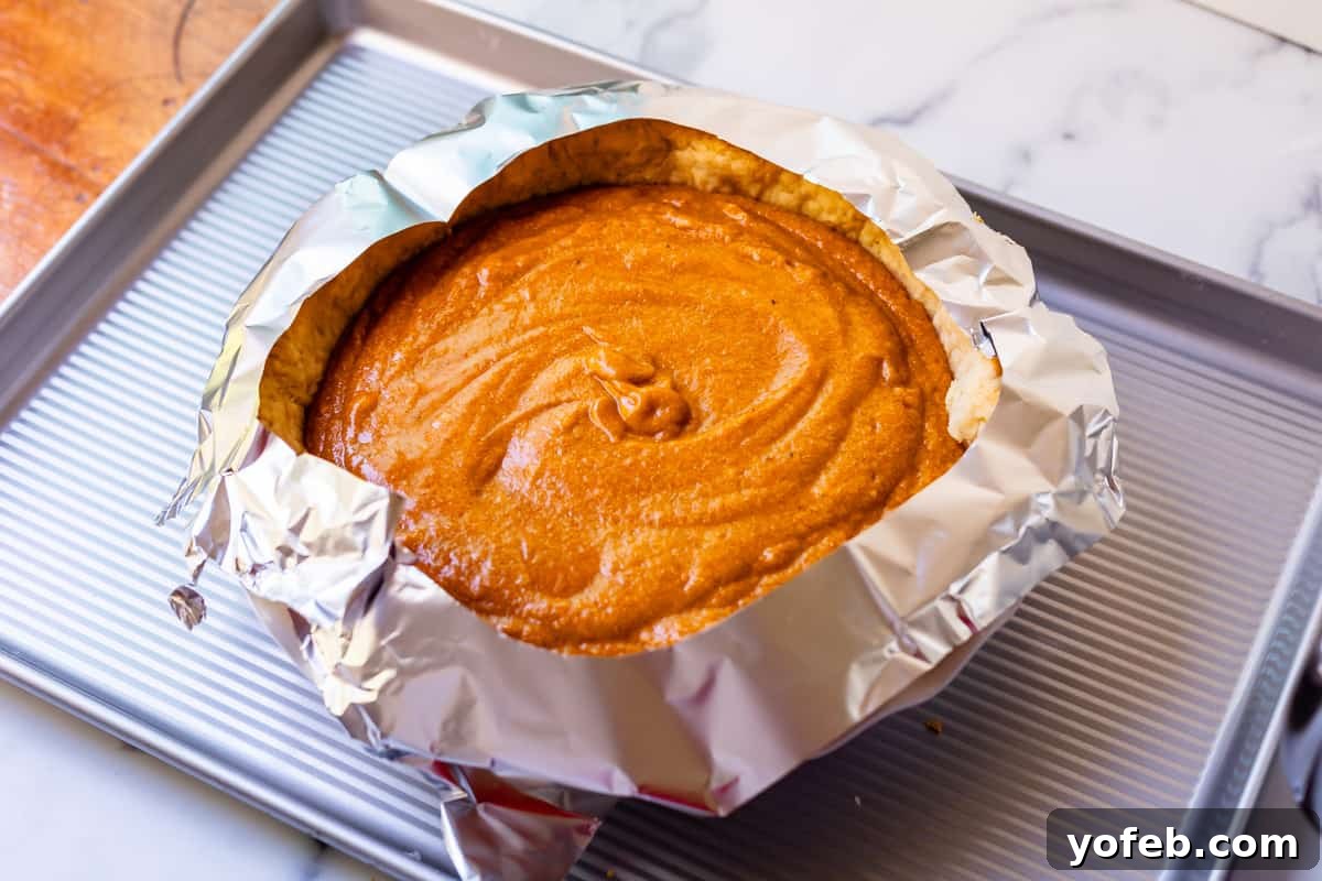 Golden Sweet Potato Pie Crowned with Salted Caramel Cream 24 tin foil with a circle cut out of it around the crust/edges of the ready to bake pie.