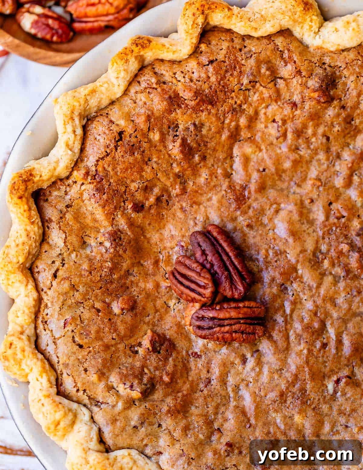 Golden Sweet Potato Pie Crowned with Salted Caramel Cream 27 looking on top of a baked homemade sweet potato pie with praline topping.
