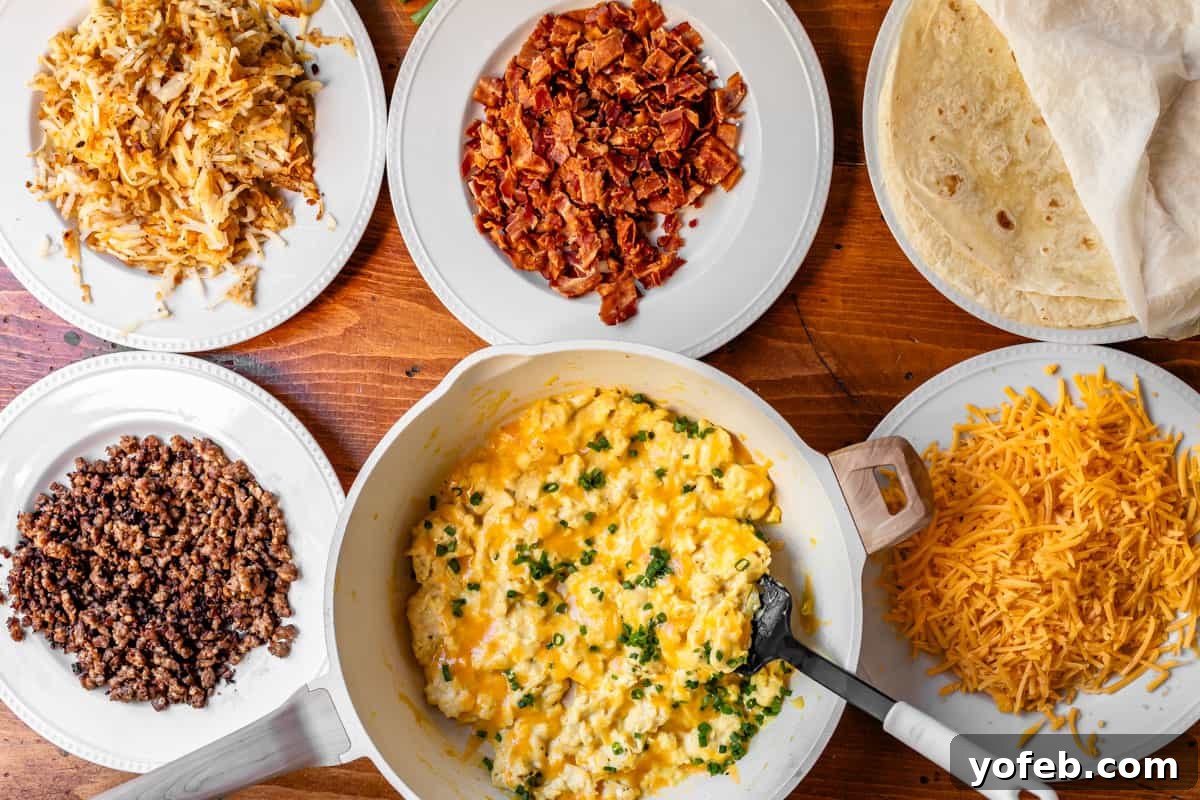 The Ultimate Make Ahead Breakfast Burrito Recipe 15 breakfast burrito ingredients laid out on plates, ready for assembly.