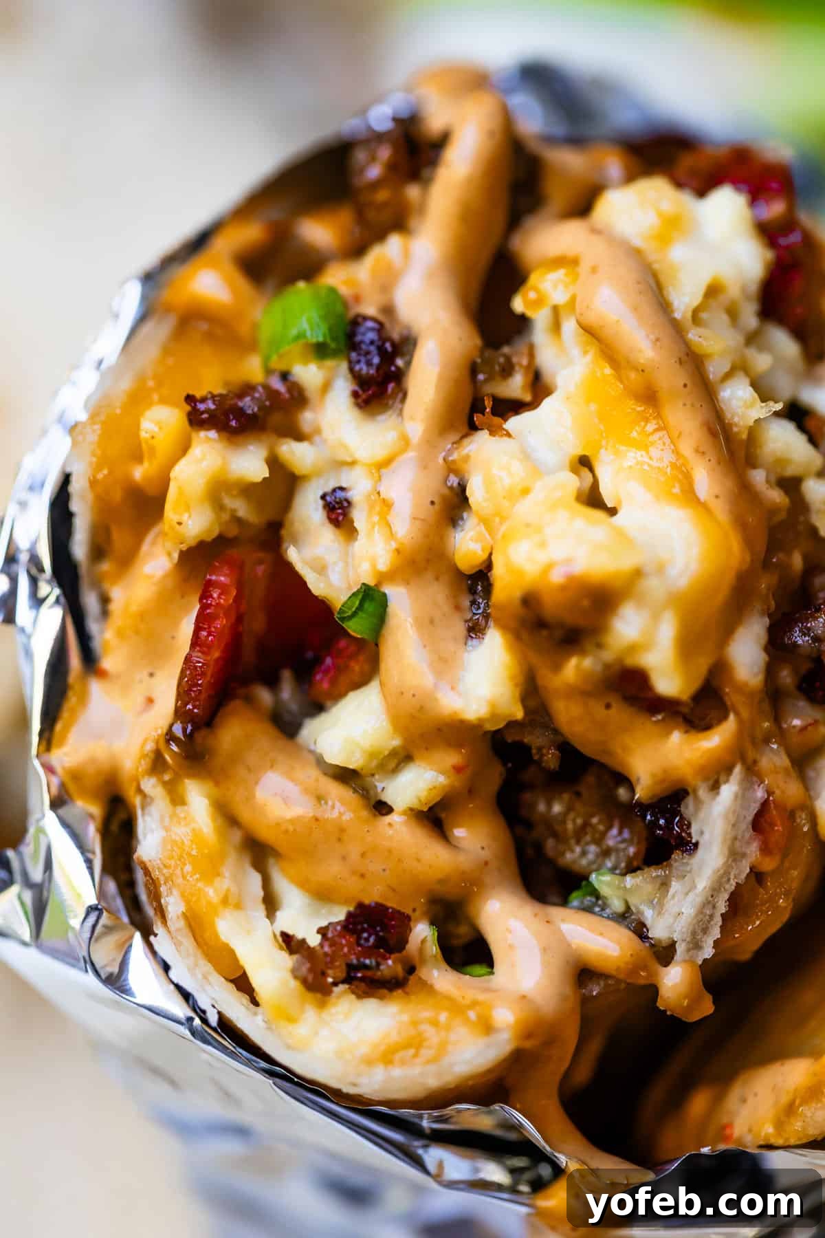 The Ultimate Make Ahead Breakfast Burrito Recipe 28 Close-up of breakfast burrito with chipotle mayo on top.