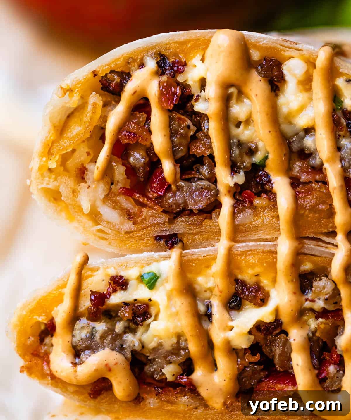 The Ultimate Make Ahead Breakfast Burrito Recipe 5 two breakfast burritos halves with meat, egg, and chipotle mayo.