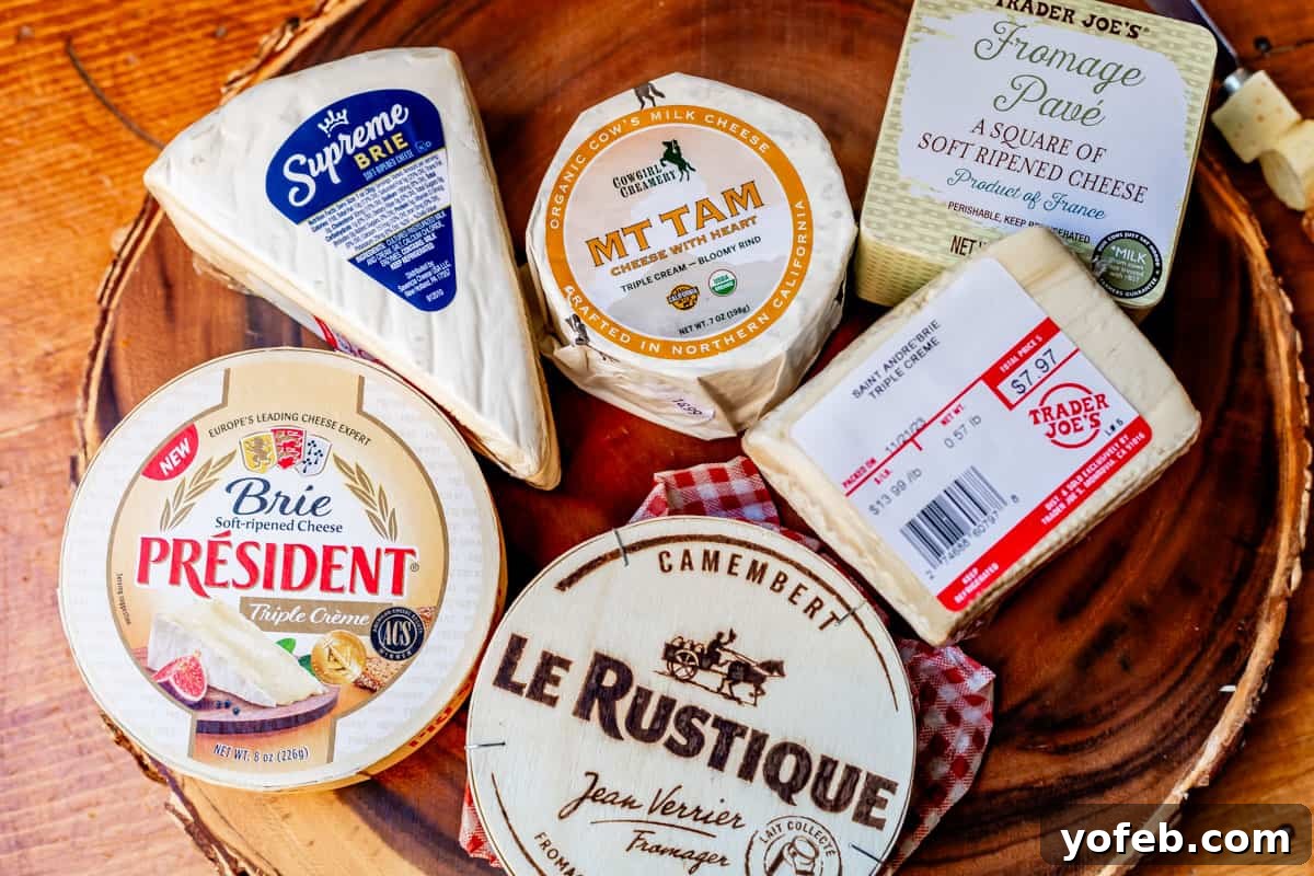 Crafting the Perfect Charcuterie Board 6 Assortment of nice triple cream cheeses in packaging arranged on a wooden display board.