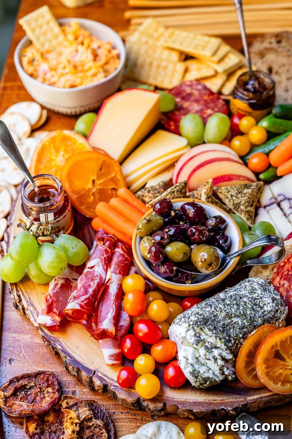 Crafting the Perfect Charcuterie Board 7 food on a wooden board ready to eat, like meats, cheese, carrots, jam, etc.