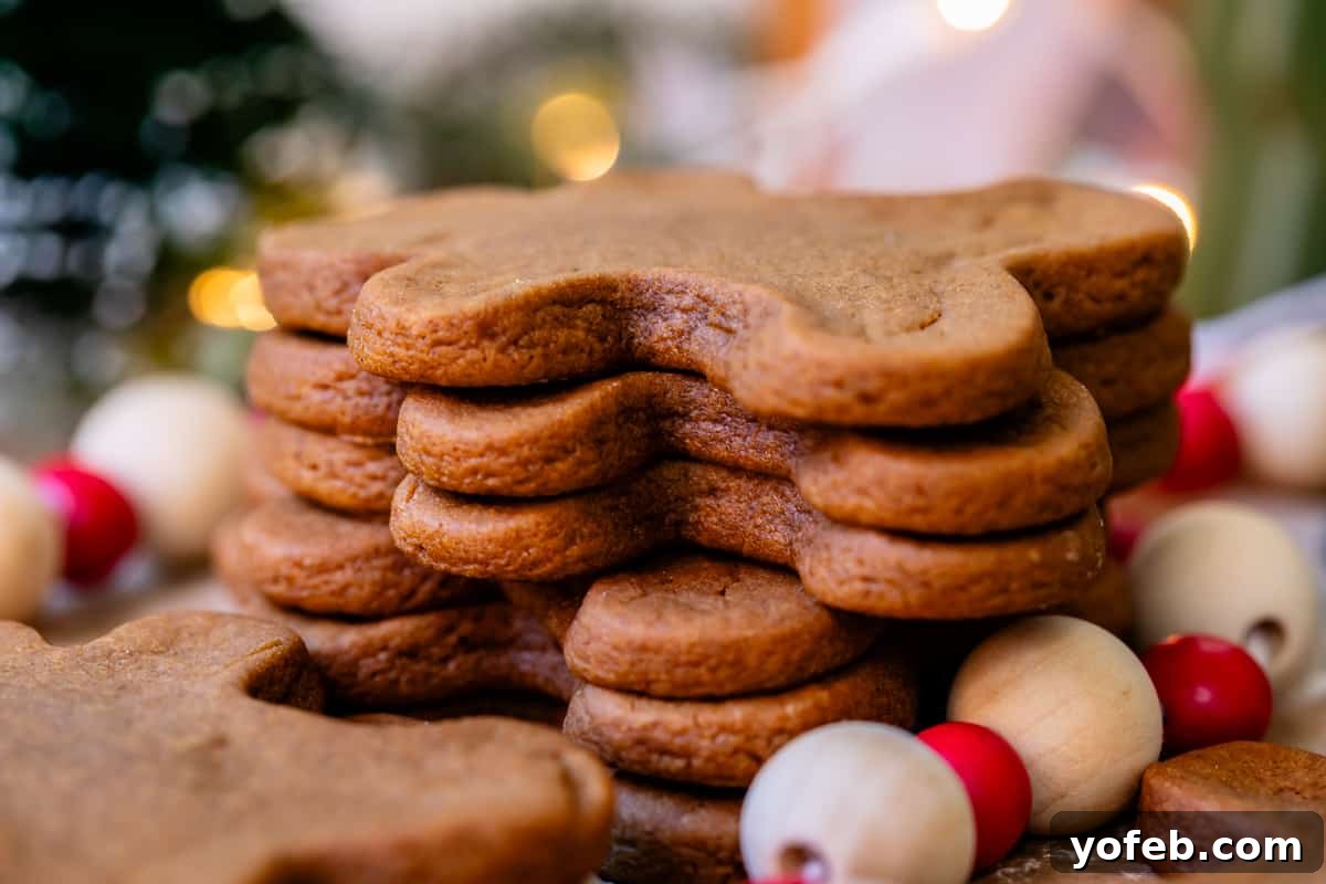 Perfectly Soft Chewy Gingerbread Men That Hold Their Shape 12 A side view of a neat stack of thick and well-shaped, baked gingerbread man cookies, highlighting their substantial thickness.