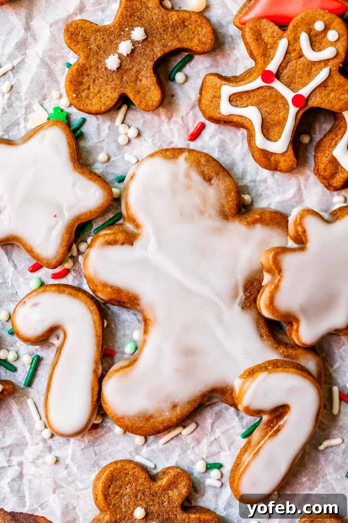Perfectly Soft Chewy Gingerbread Men That Hold Their Shape 13 Glazed gingerbread man cookies artfully arranged on parchment paper, adorned with festive sprinkles.