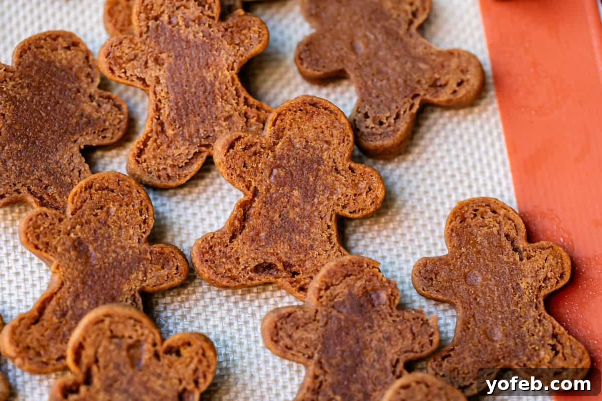 Perfectly Soft Chewy Gingerbread Men That Hold Their Shape 27 The flipped side of several gingerbread men, showing dark spots on their backs which indicate they are perfectly baked for a soft texture.