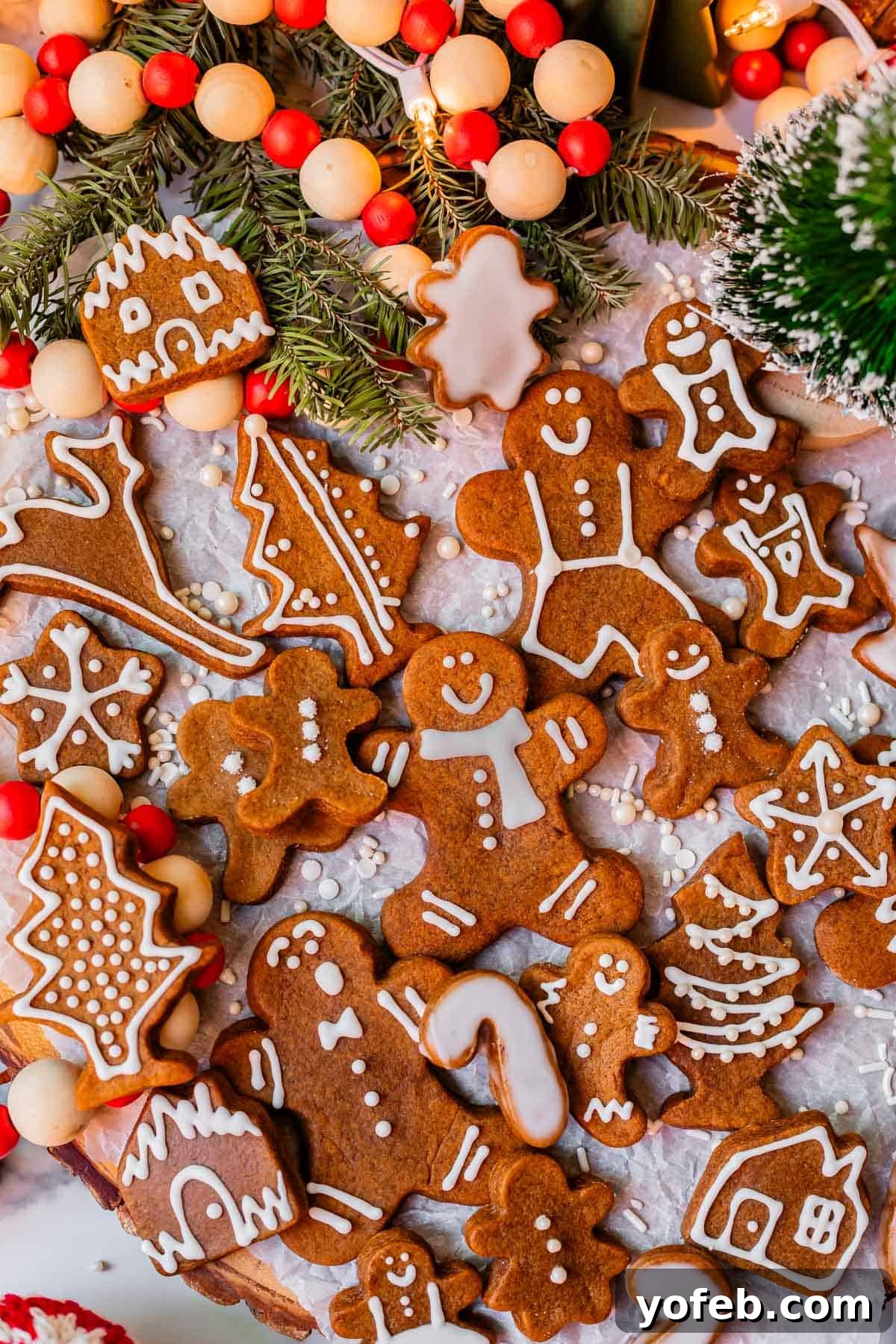Perfectly Soft Chewy Gingerbread Men That Hold Their Shape 7 Several dozen gingerbread man cookies with elegant white icing, neatly lined up on white parchment paper.