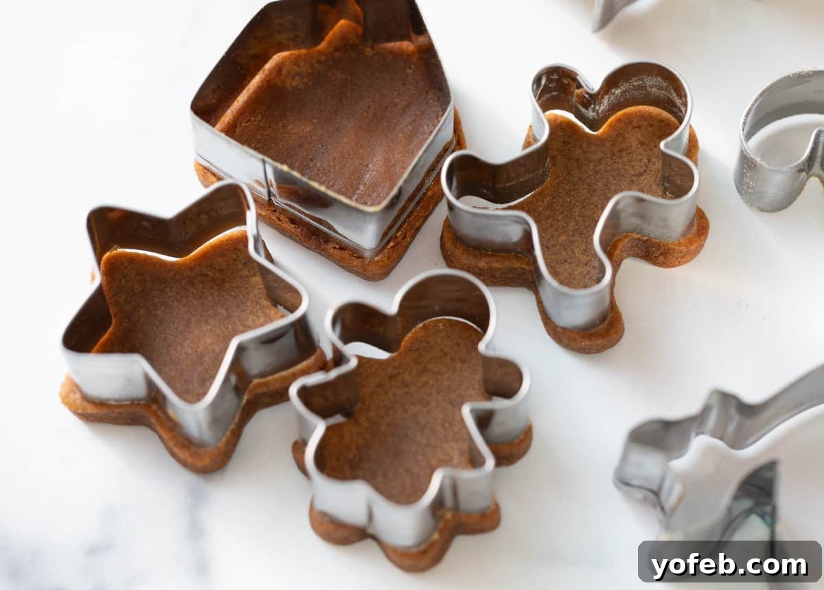 Perfectly Soft Chewy Gingerbread Men That Hold Their Shape 9 Four cut-out and baked gingerbread cookies with their respective cutters placed on top to visually demonstrate that they did not spread during baking.
