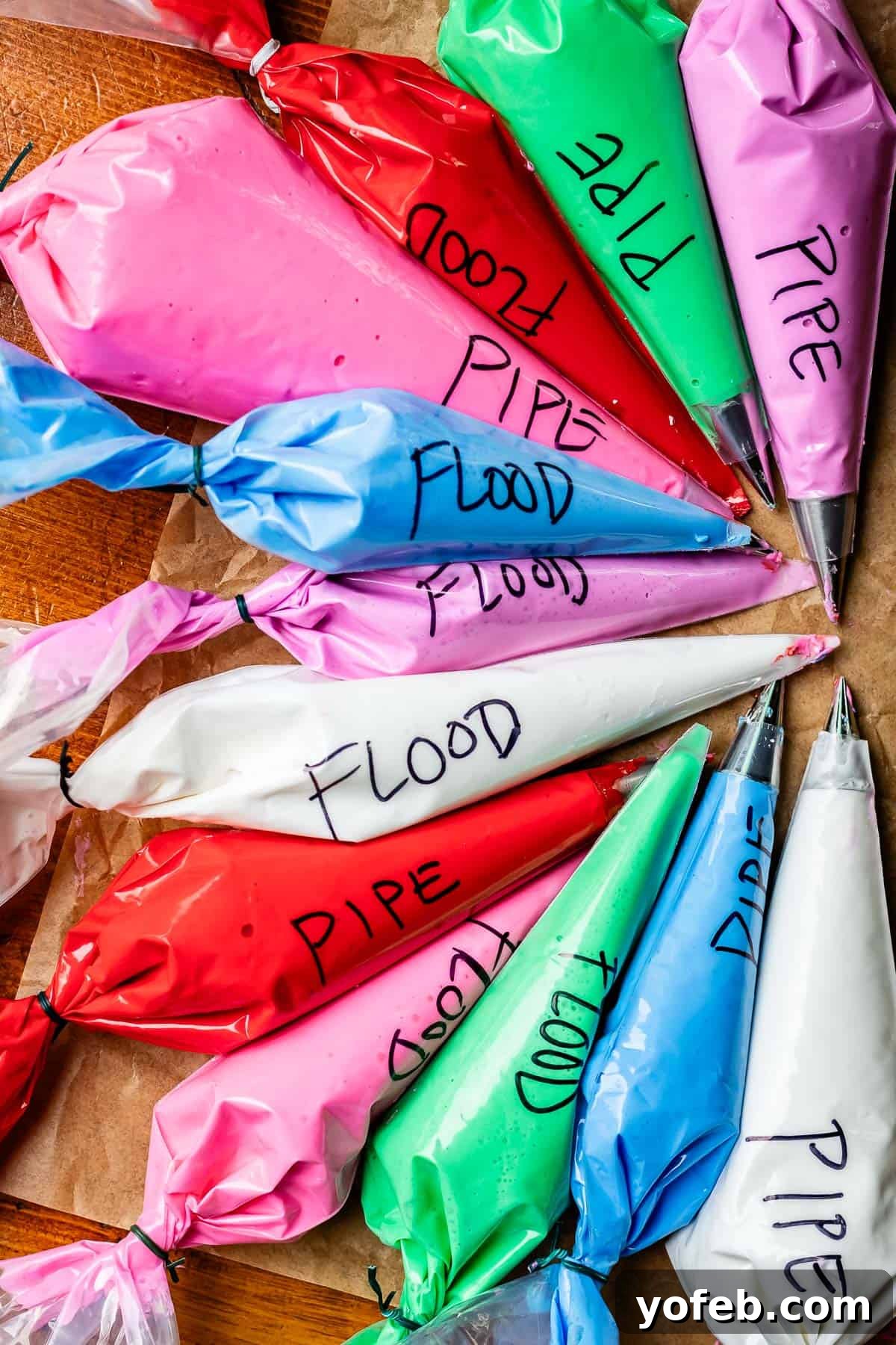 Beginner's Guide to Perfect Royal Icing 26 several piping bags filled with various colors of icing, with either pipe or flood written on the side.