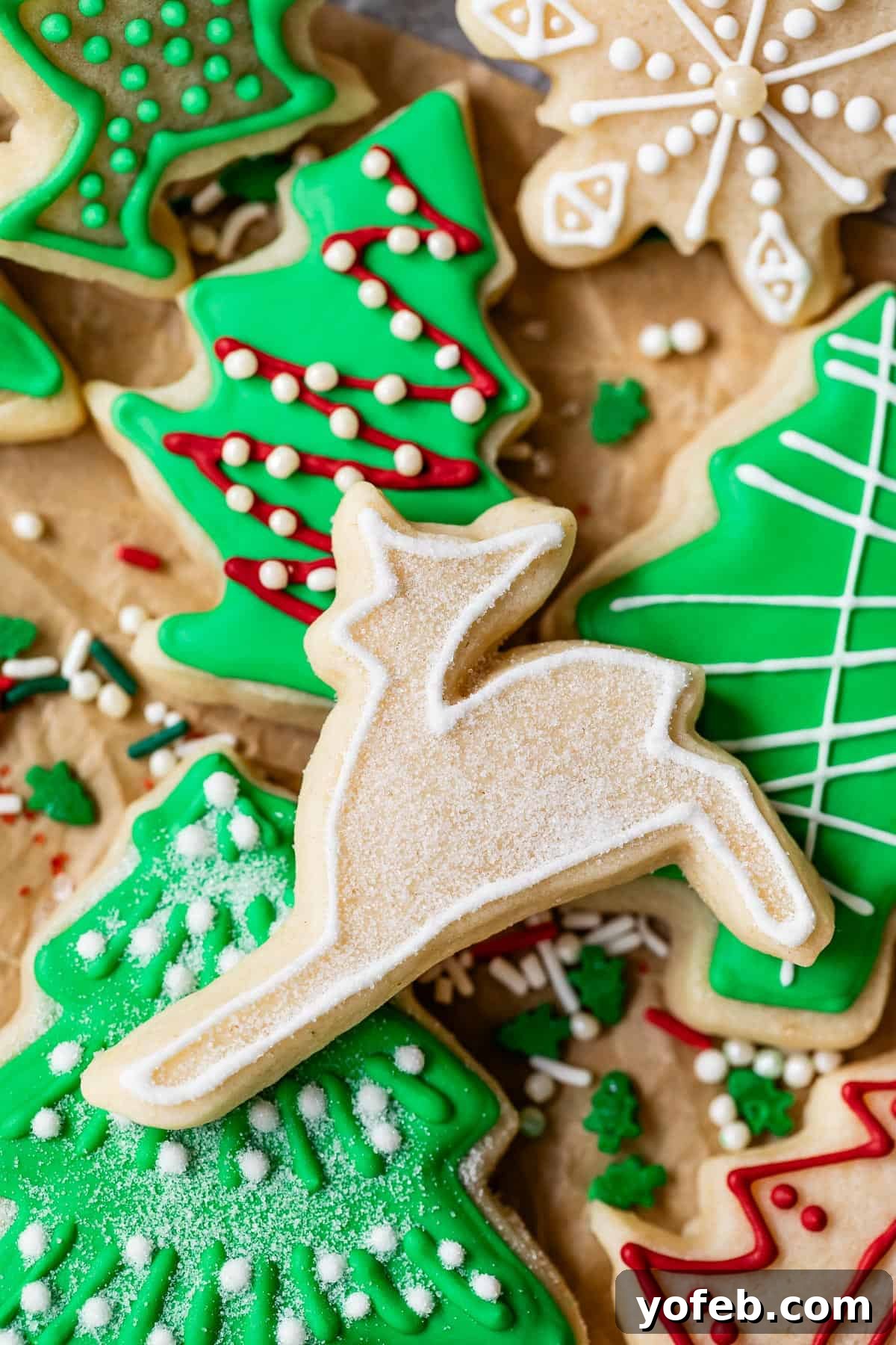 Beginner's Guide to Perfect Royal Icing 38 Reindeer sugar cookie with outline done in white royal icing on top of assortment of Christmas sugar cookies.