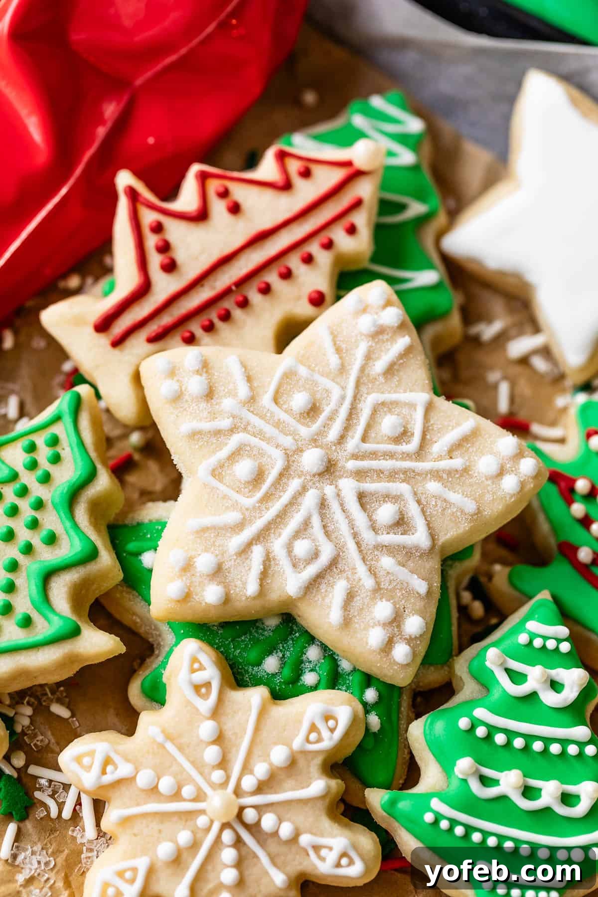 Beginner's Guide to Perfect Royal Icing 5 Star sugar cookie with royal icing design and sugar decoration on top of pile of other Christmas cookies.