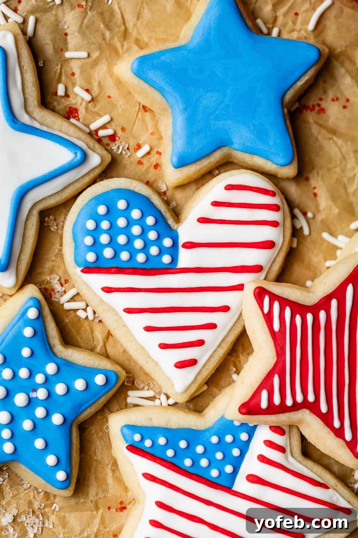 Beginner's Guide to Perfect Royal Icing 6 Sugar cookies decorated for July 4th including heart and stars with red, white, and blue icing.