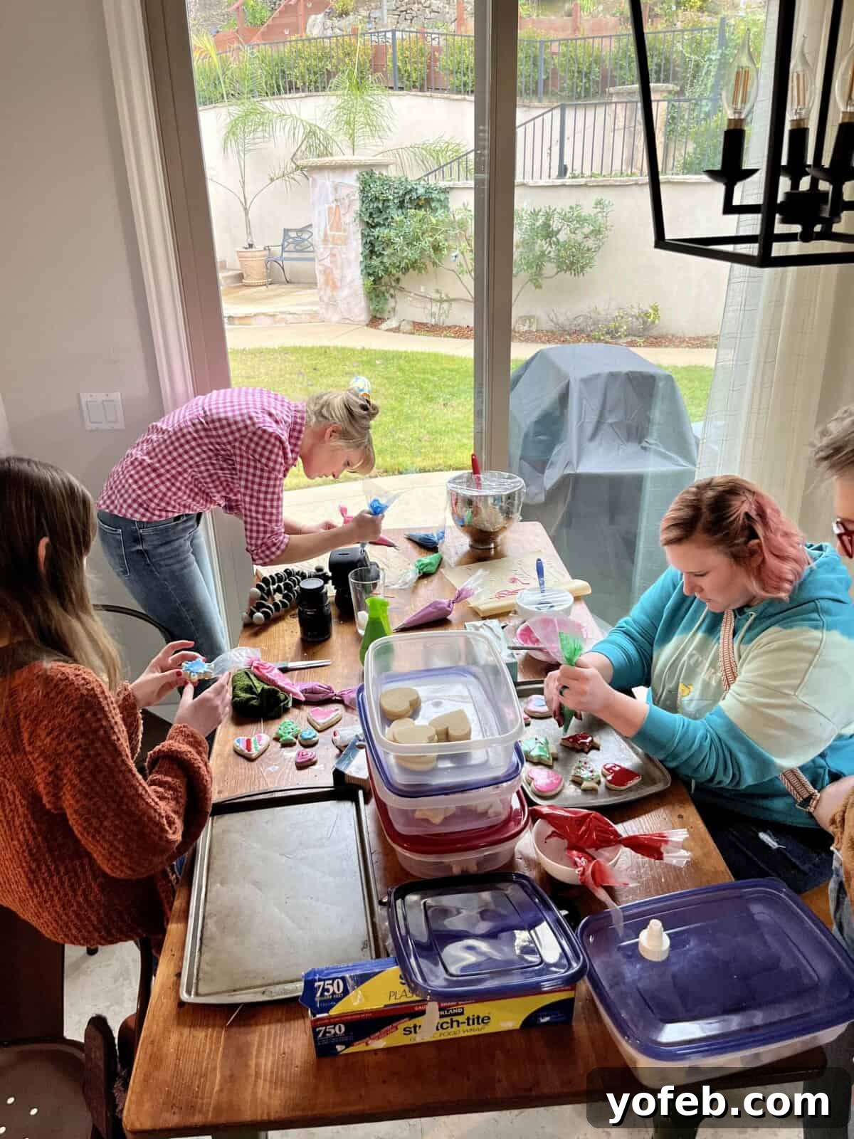 Beginner's Guide to Perfect Royal Icing 7 women around a wood table decorating cookies.