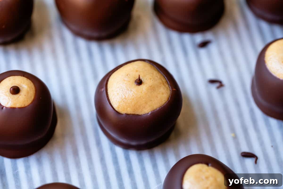 Irresistible Buckeye Ball Recipe 24 Buckeye with the toothpick hole filled with chocolate, giving it a 'boob' appearance.