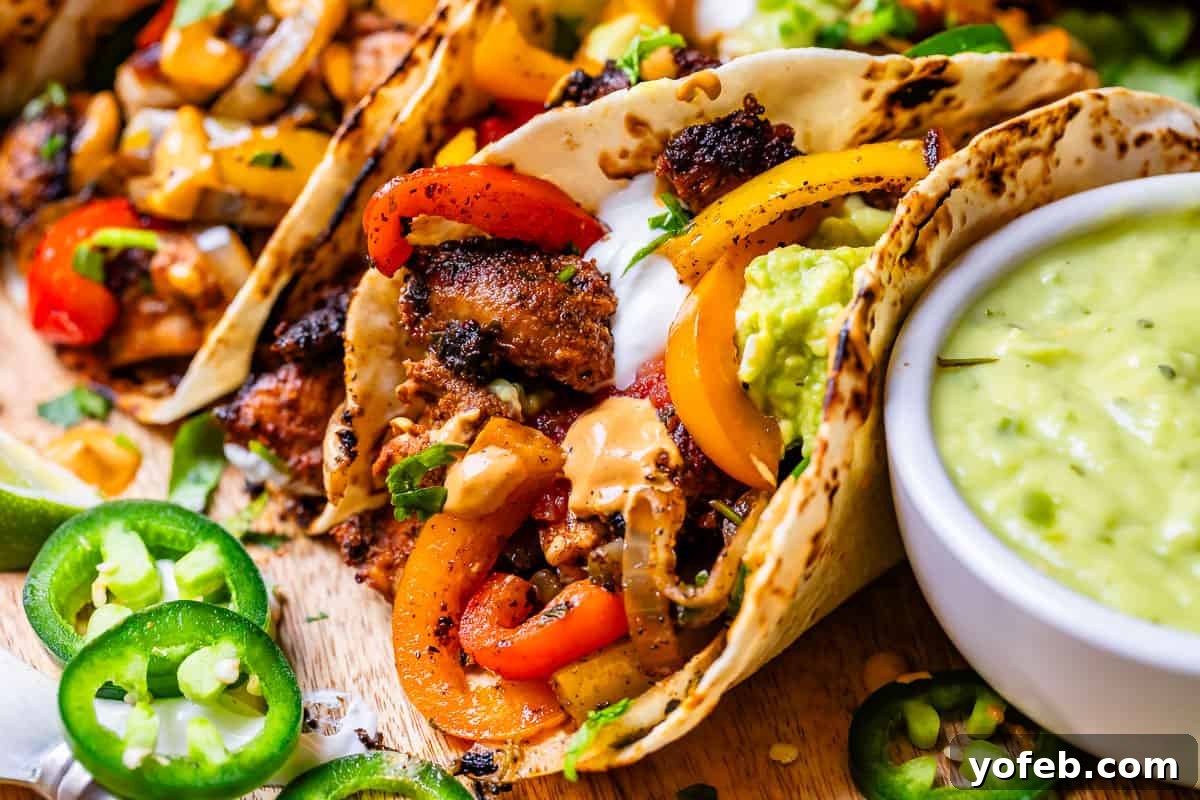 My Chicken Fajitas Awakening 24 a filled chicken fajita next to a bowl with creamy tomatillo jalapeno sauce for dipping.