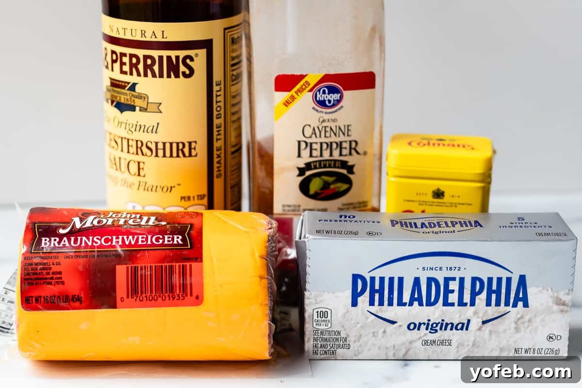 The five essential ingredients for Liver Pâté: a package of Braunschweiger, a block of cream cheese, a bottle of Worcestershire sauce, a small jar of dry mustard powder, and a shaker of cayenne pepper.