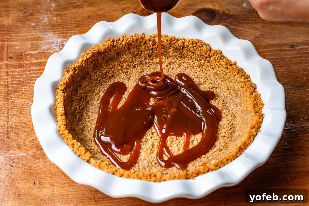Luscious Caramel Swirled Coconut Cream Pie 16 homemade caramel being poured on top of a baked crust in a pie pan.